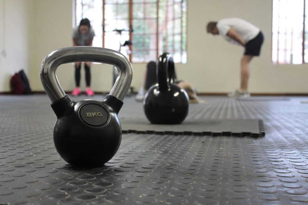 Persoon in EMS-trainingspak met elektroden die voordelen van EMS-training demonstreert