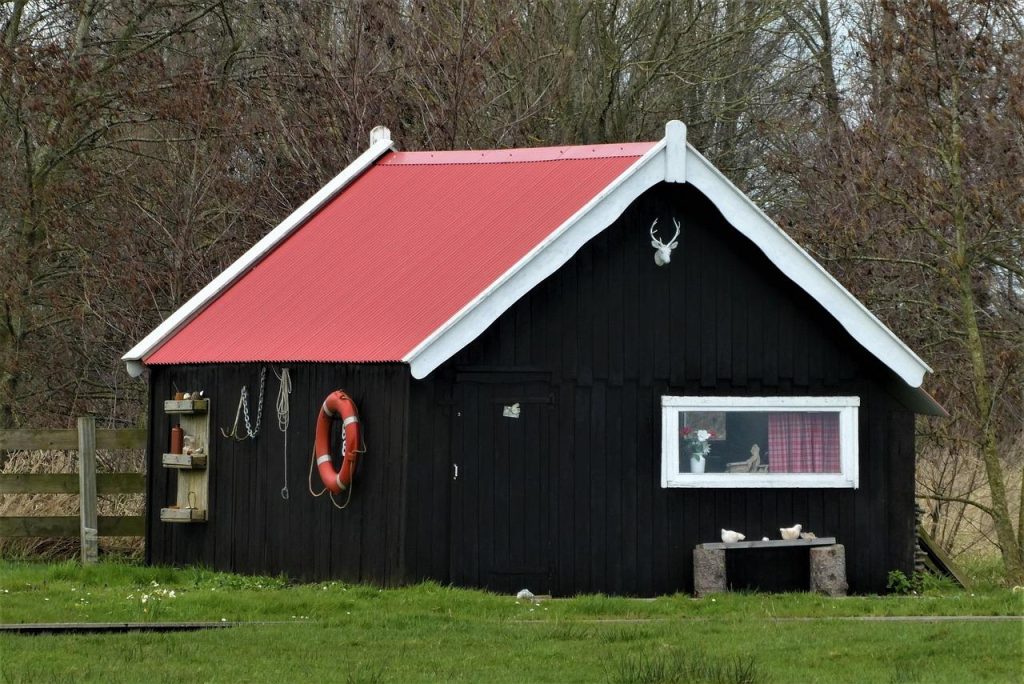 Moderne blokhut met tuinoverkapping en stijlvolle houten constructie in een groene tuin