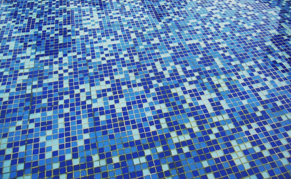 Hoogwaterlijn zwembad met strak design en water tot bijna aan de rand in een moderne tuin